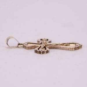 Gold cross pendant on white background.