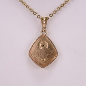 Gold pendant with chain on display.