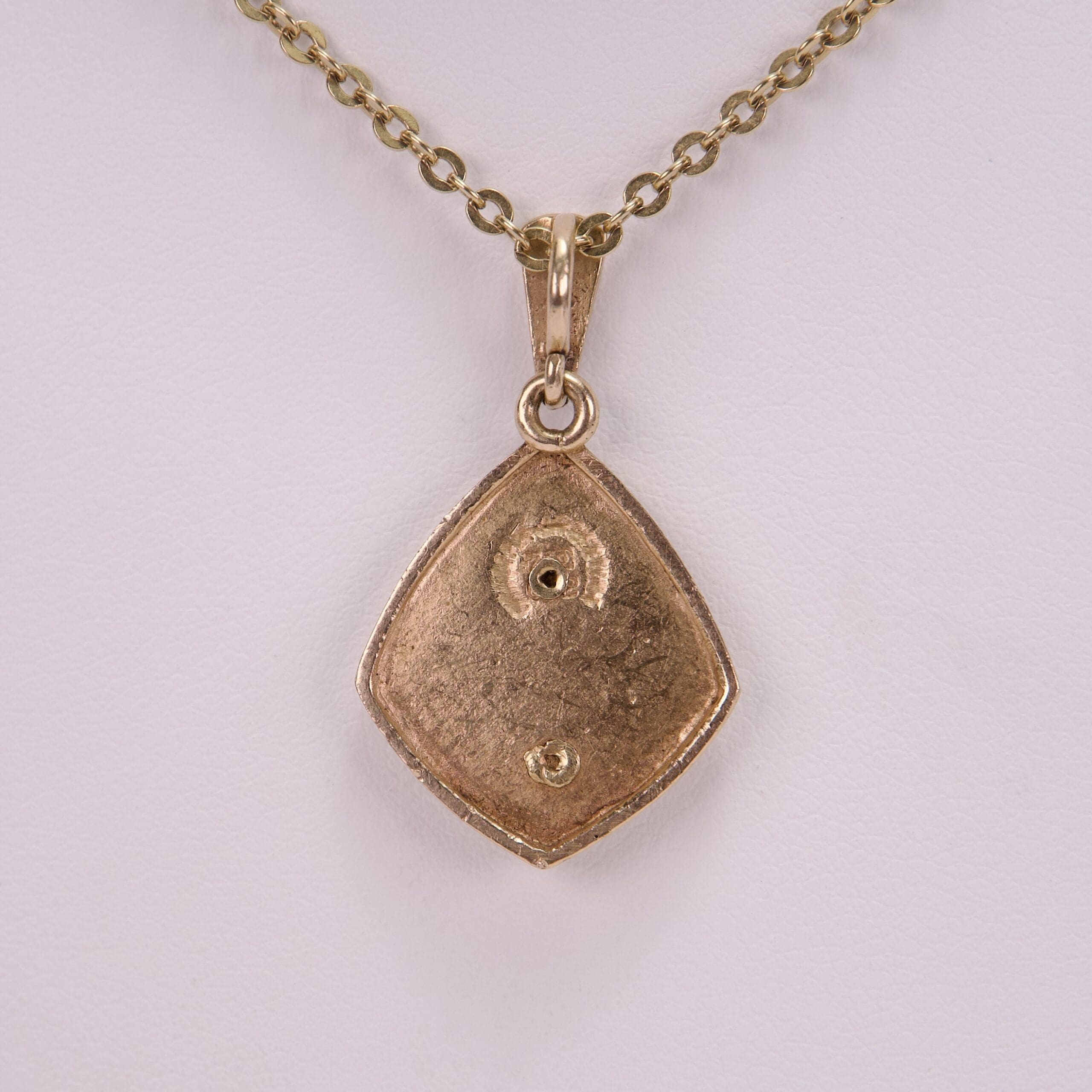 Gold pendant with chain on display.