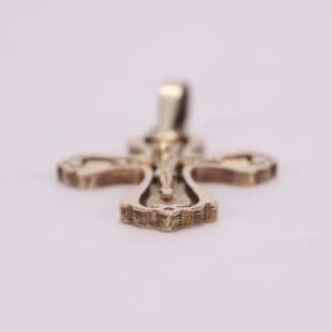 Gold cross pendant on soft background.