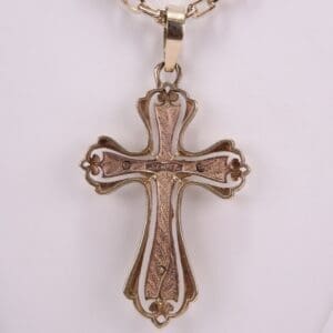 Ornate gold cross pendant on chain.