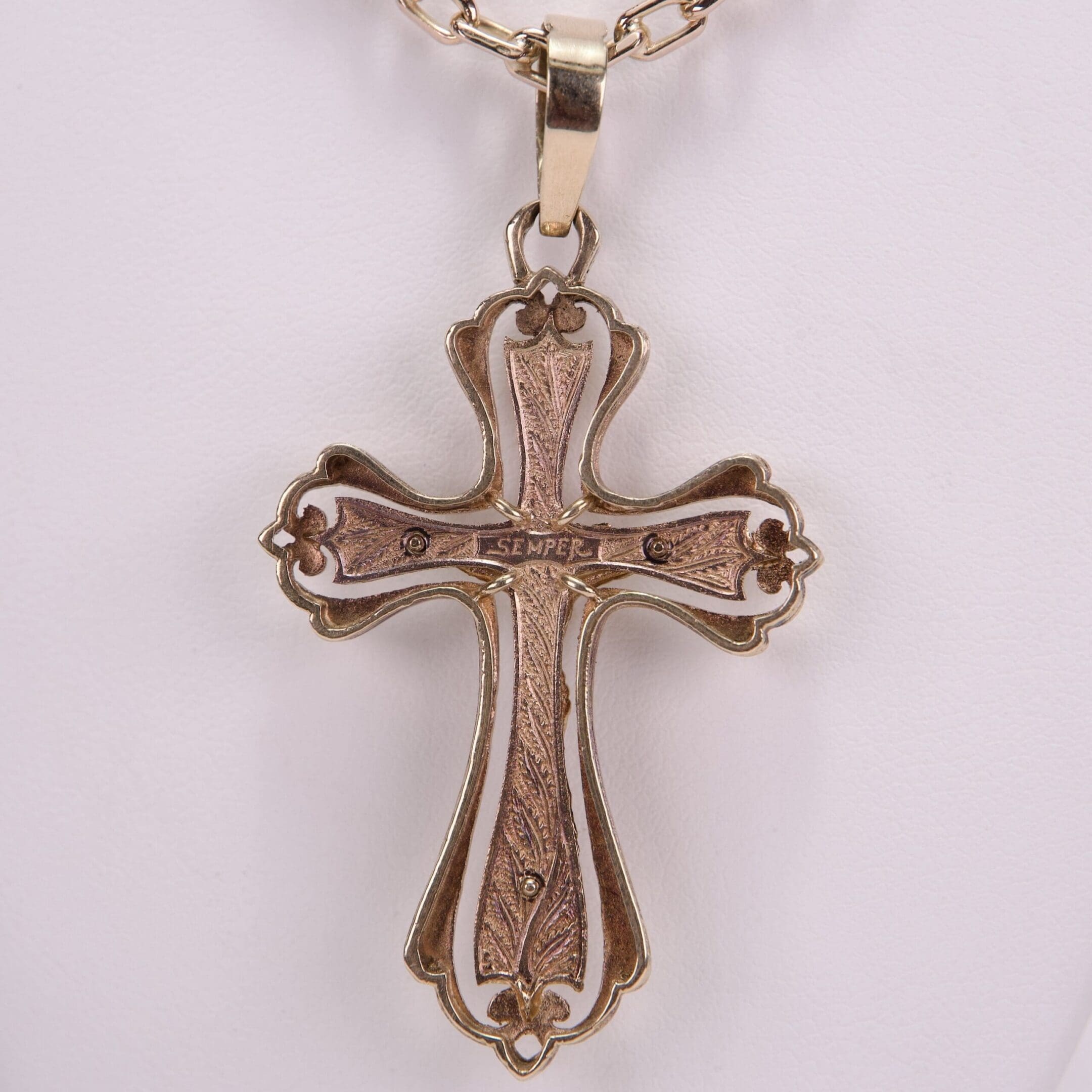 Ornate gold cross pendant on chain.