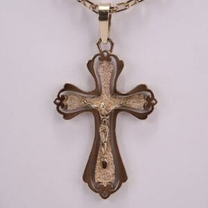 Ornate gold cross pendant on chain.