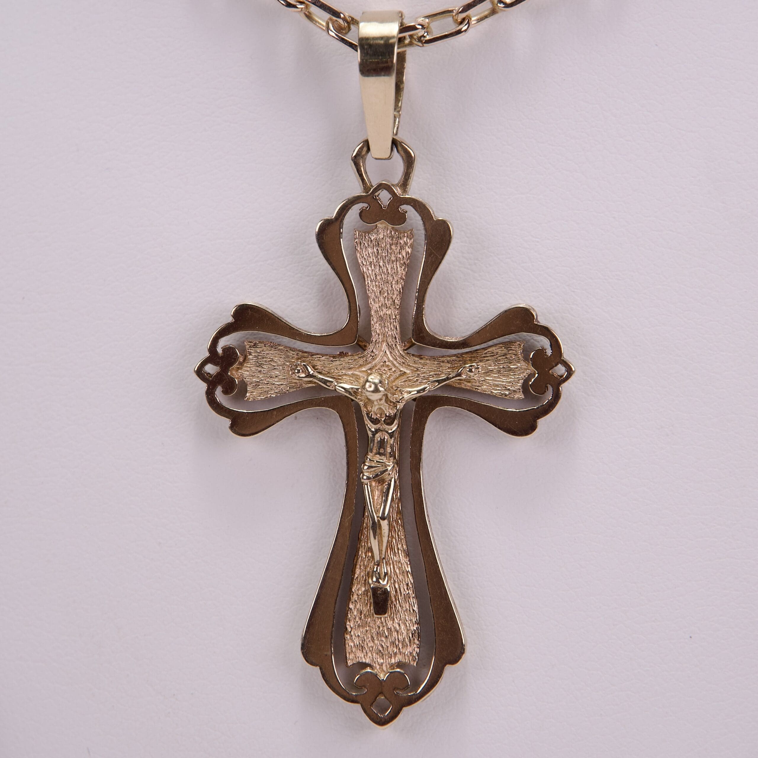 Ornate gold cross pendant on chain.