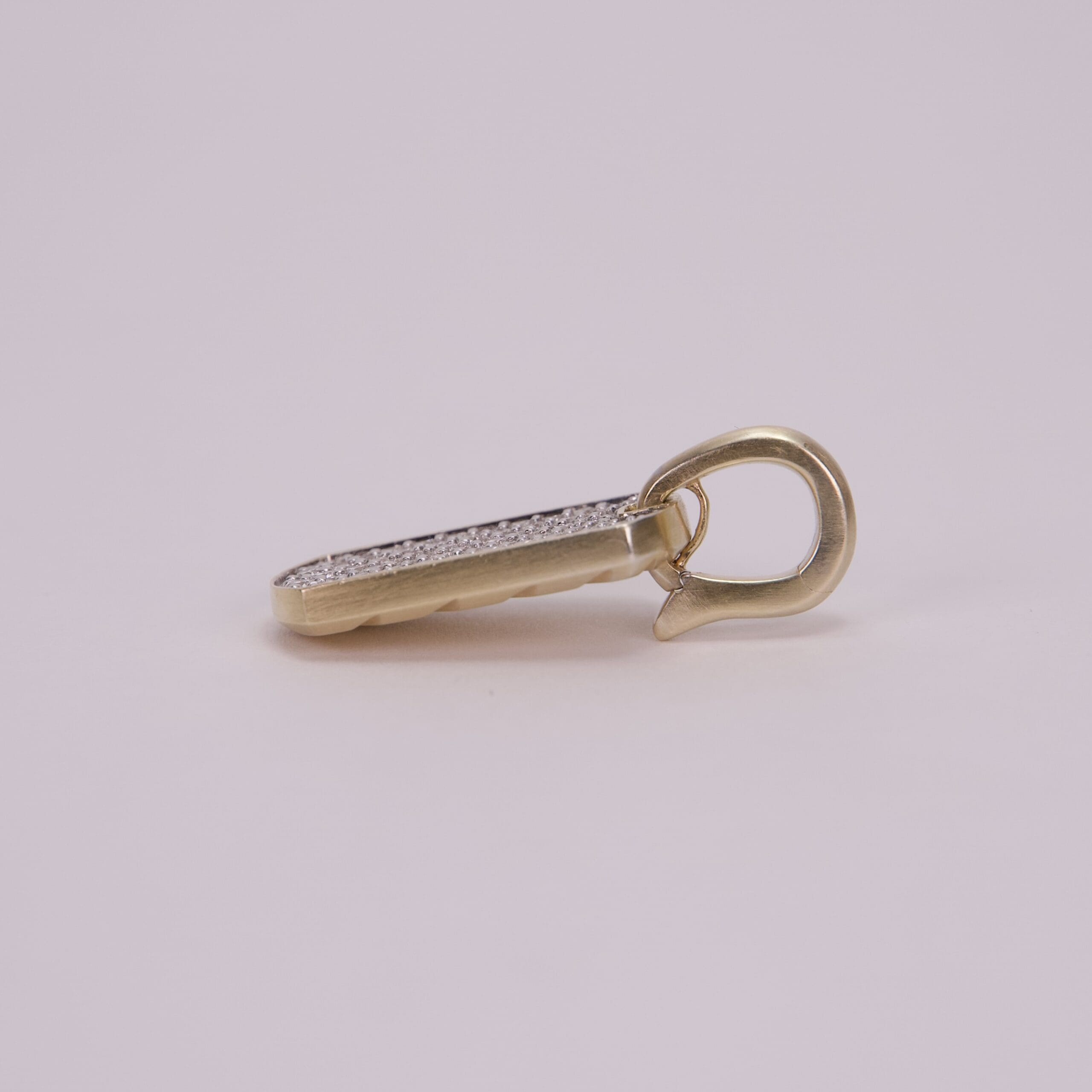 Gold and silver pendant on plain background.