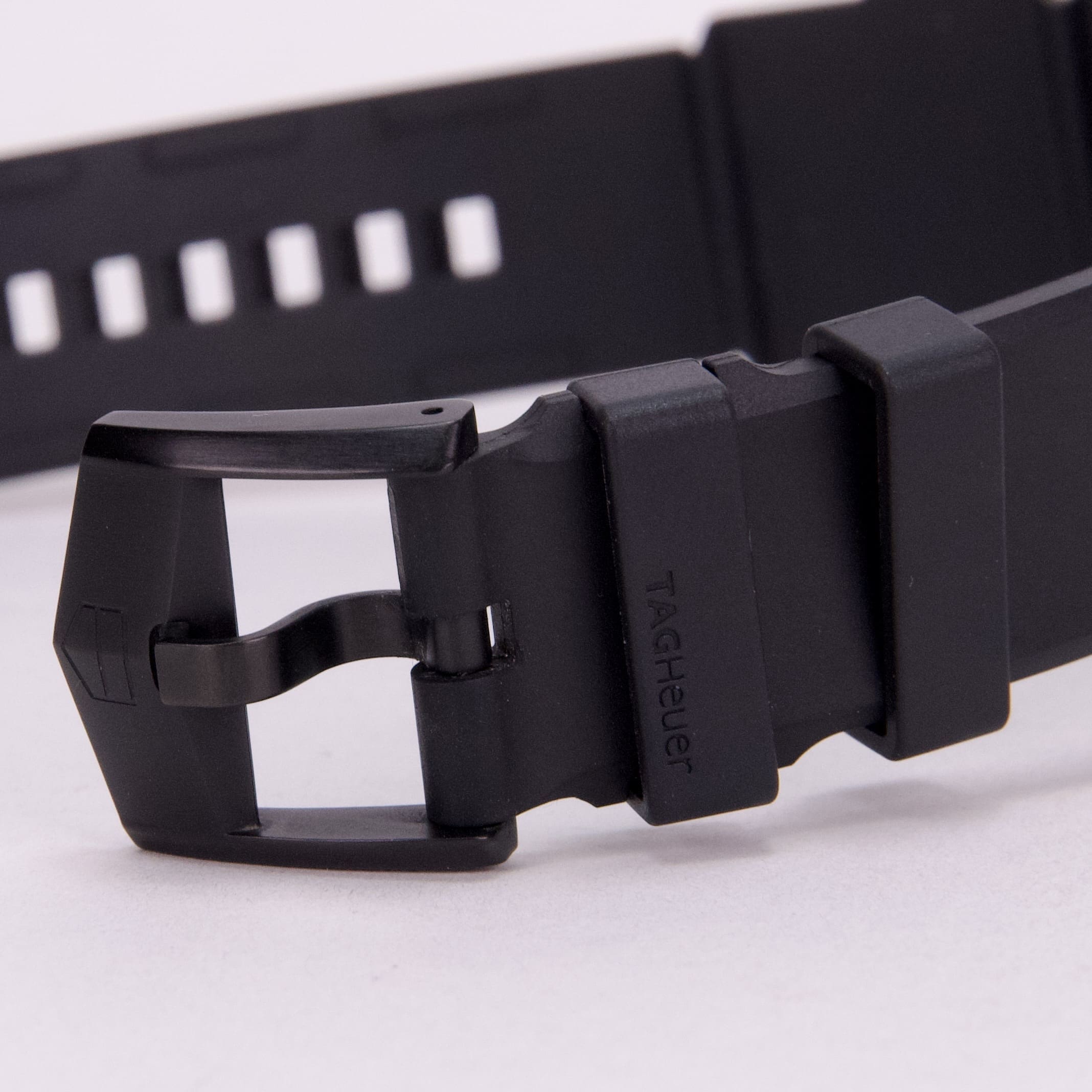 Black watch strap with buckle, close-up.