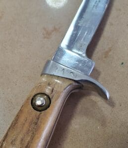 Knife with wooden handle on surface.