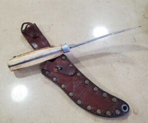 Bone-handled knife with brown leather sheath.
