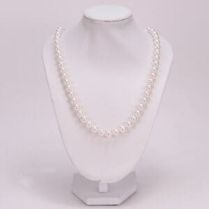 White pearl necklace on display stand.