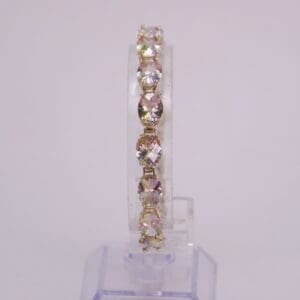 Gold bracelet with sparkling gemstones on display.