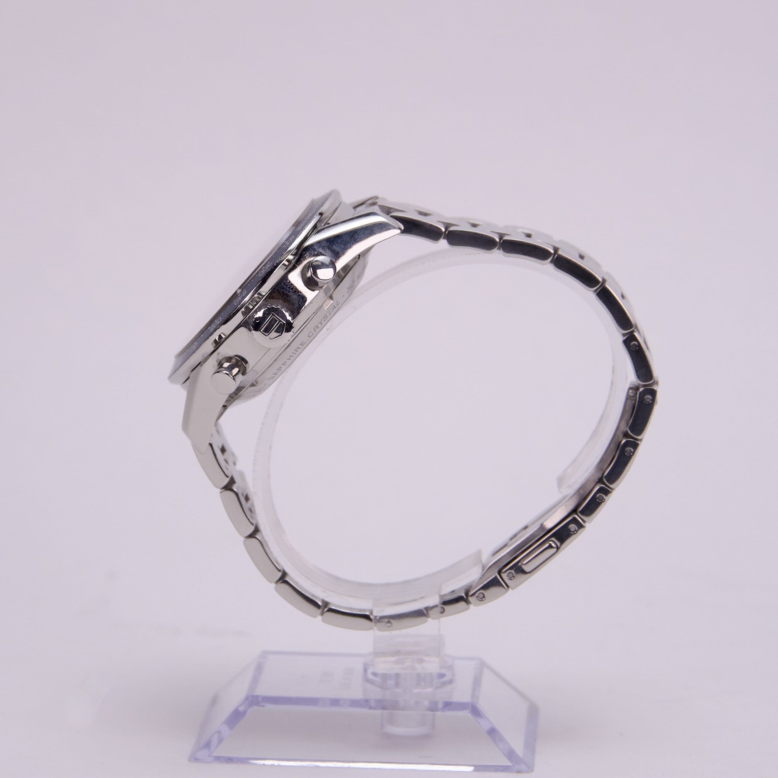 Silver wristwatch displayed on a plastic stand.