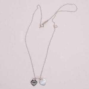 Silver heart pendant necklace with two charms.