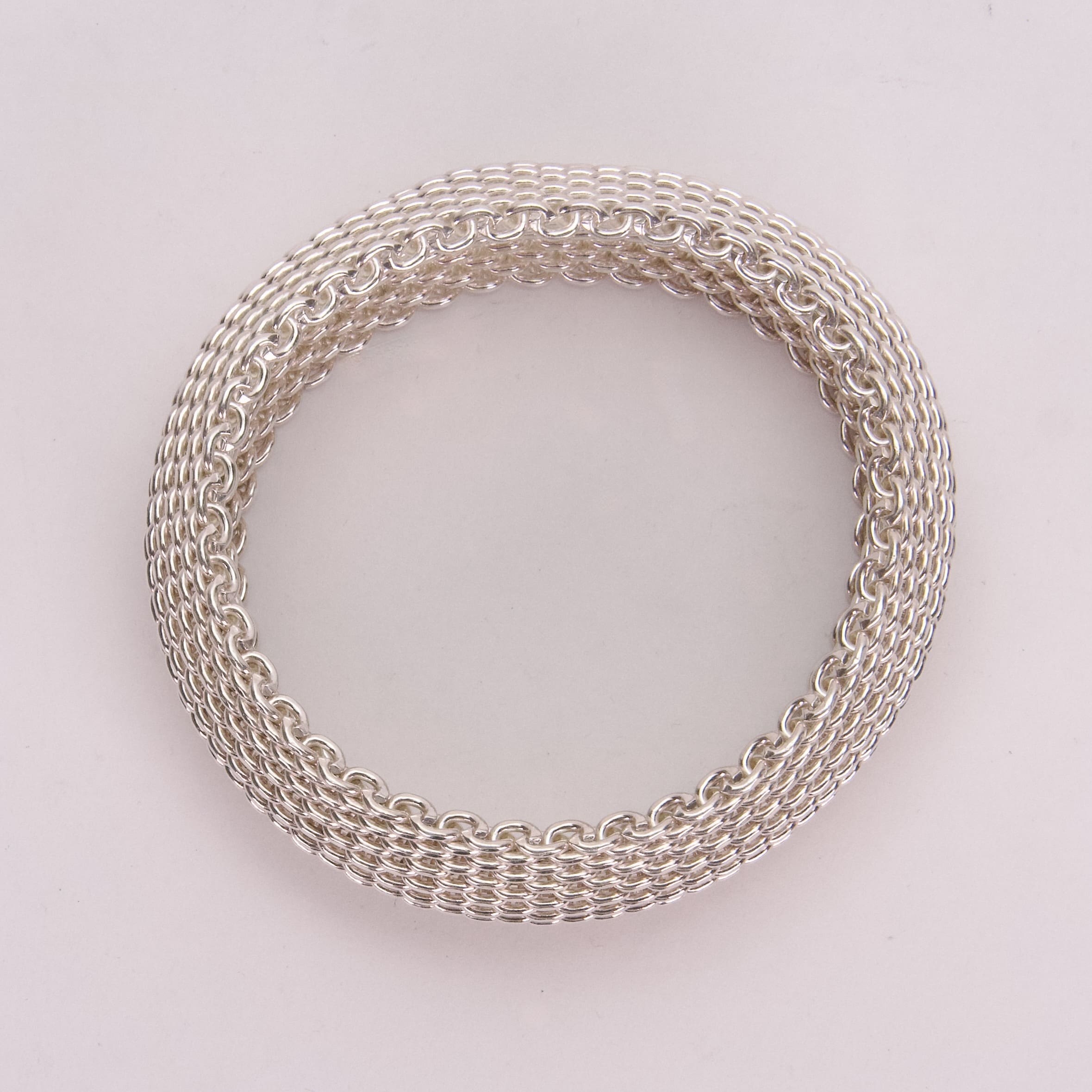Silver chainmail bracelet on white background.