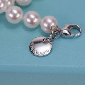 Pearl necklace with silver tag and clasp.