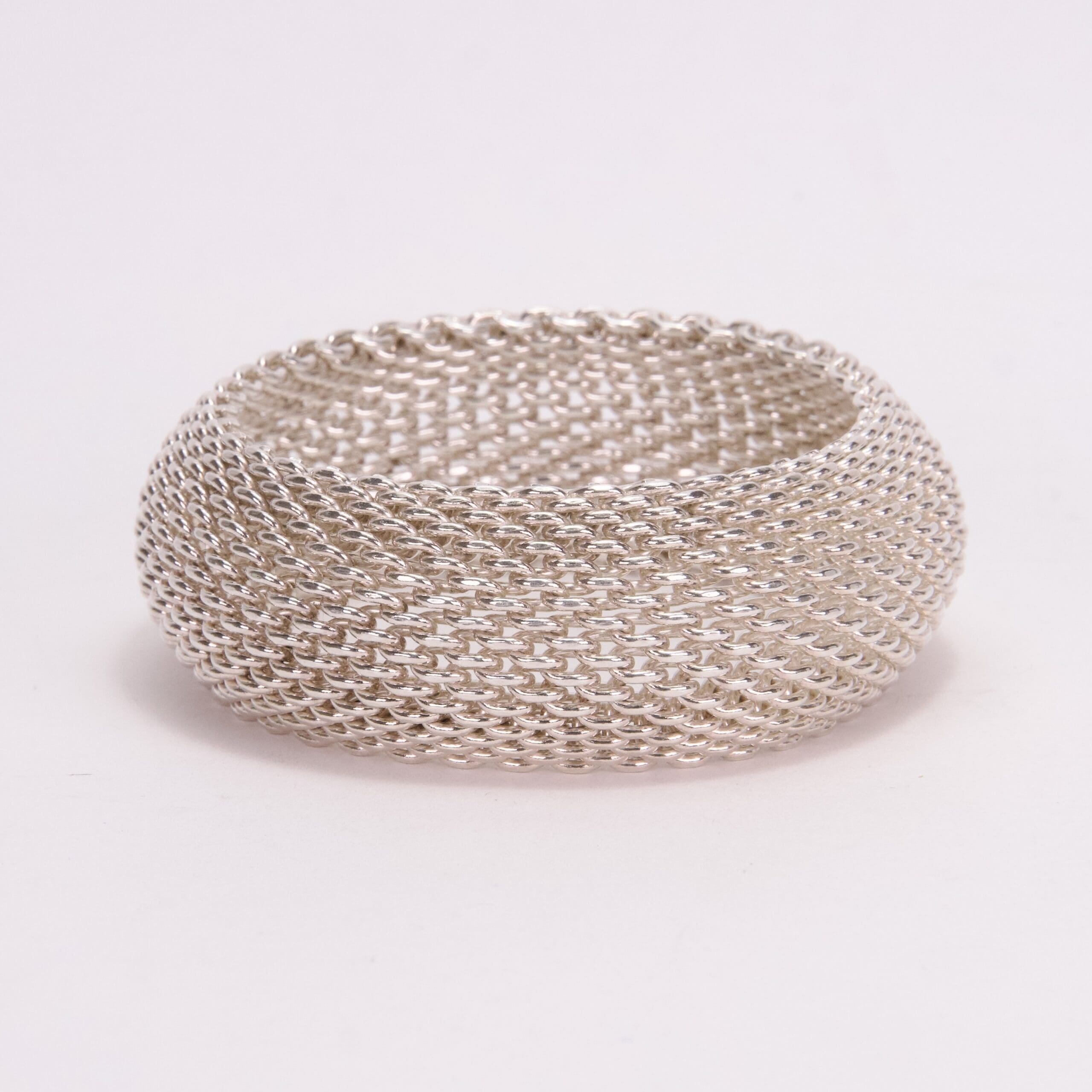 Silver mesh bracelet on white background.