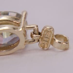 Gold pendant with a colorful gemstone.