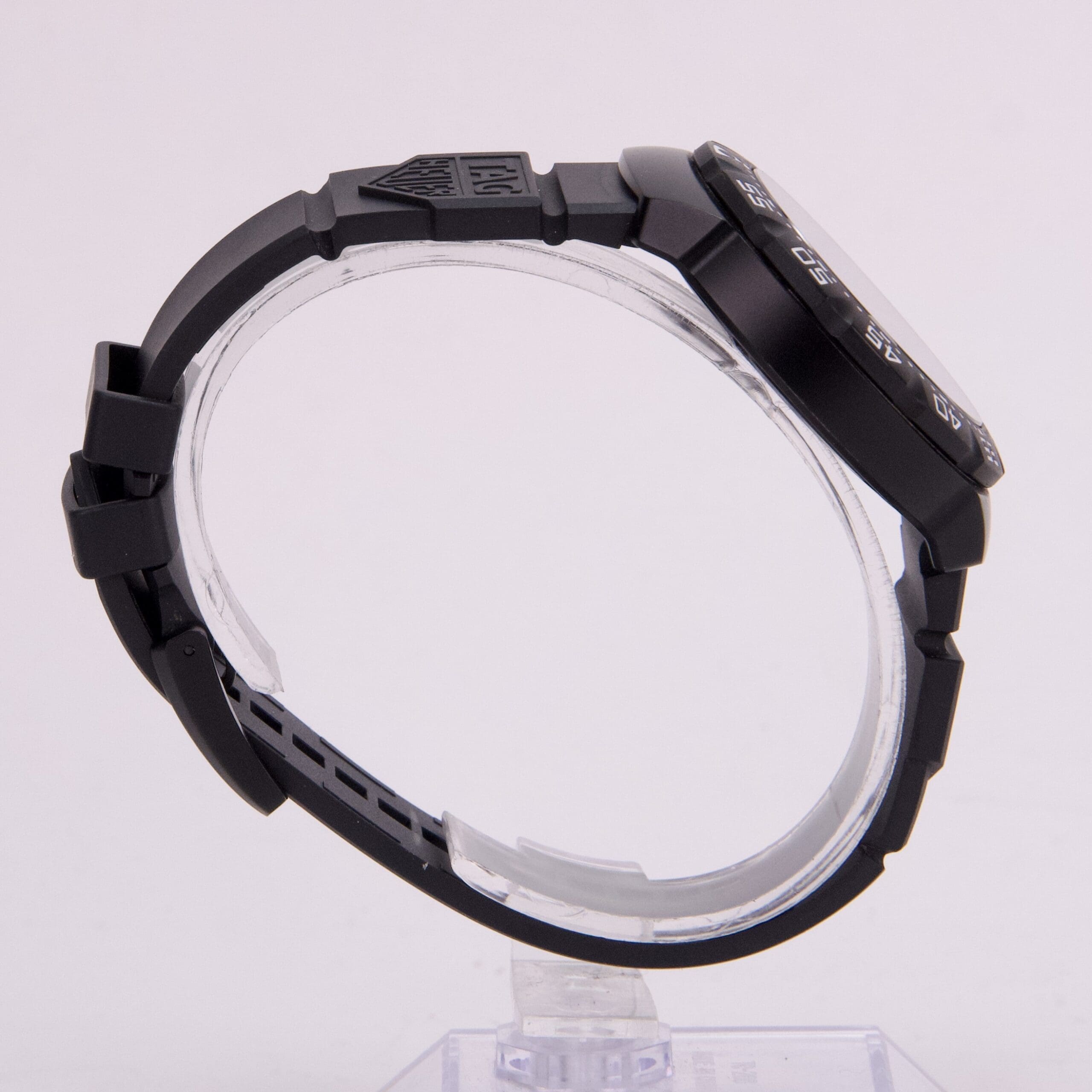Black wristwatch with rubber strap, side view.