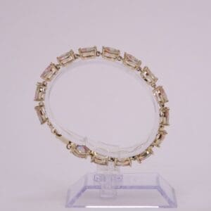 Gold bracelet with rectangular pink gemstones.