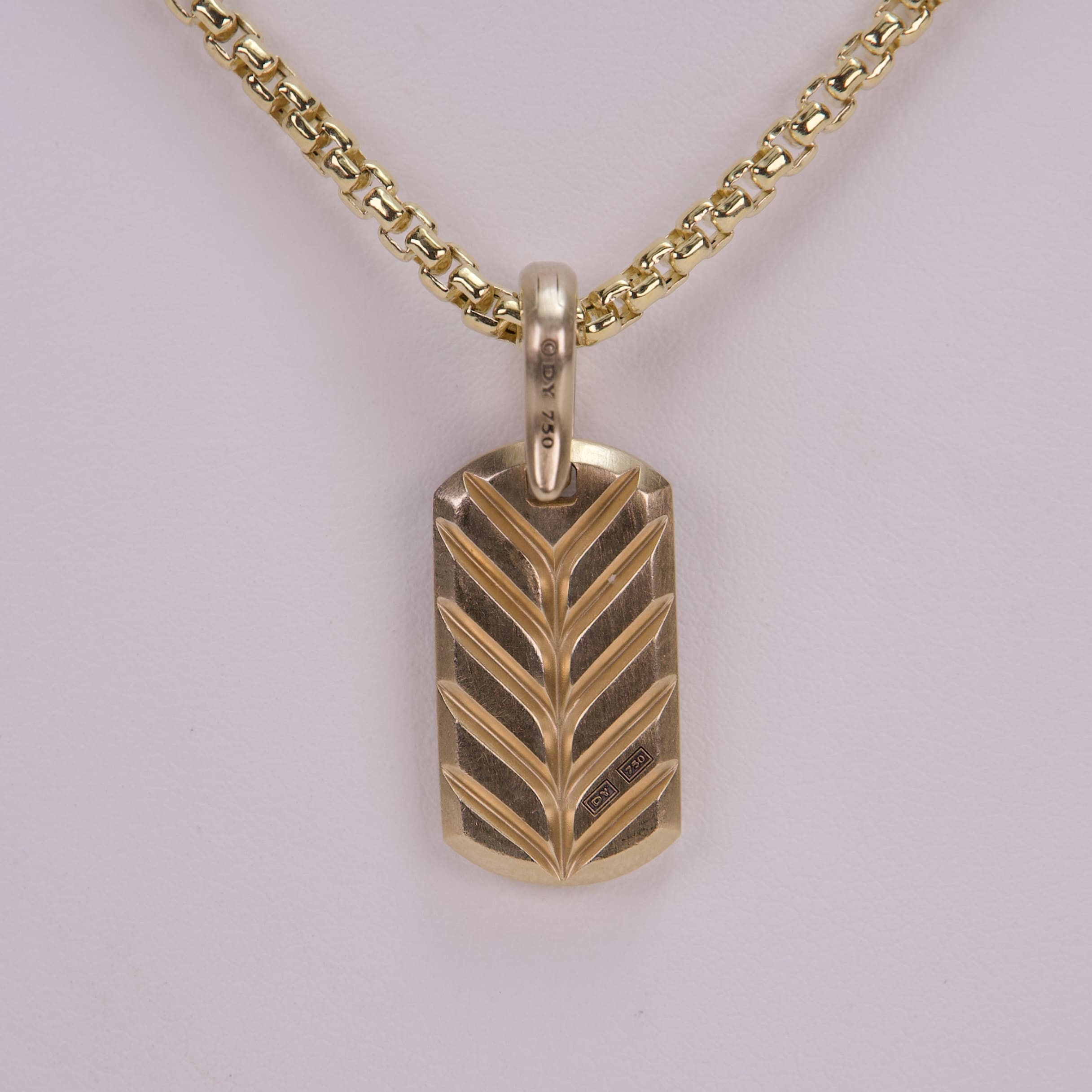 Gold pendant with chevron pattern necklace.