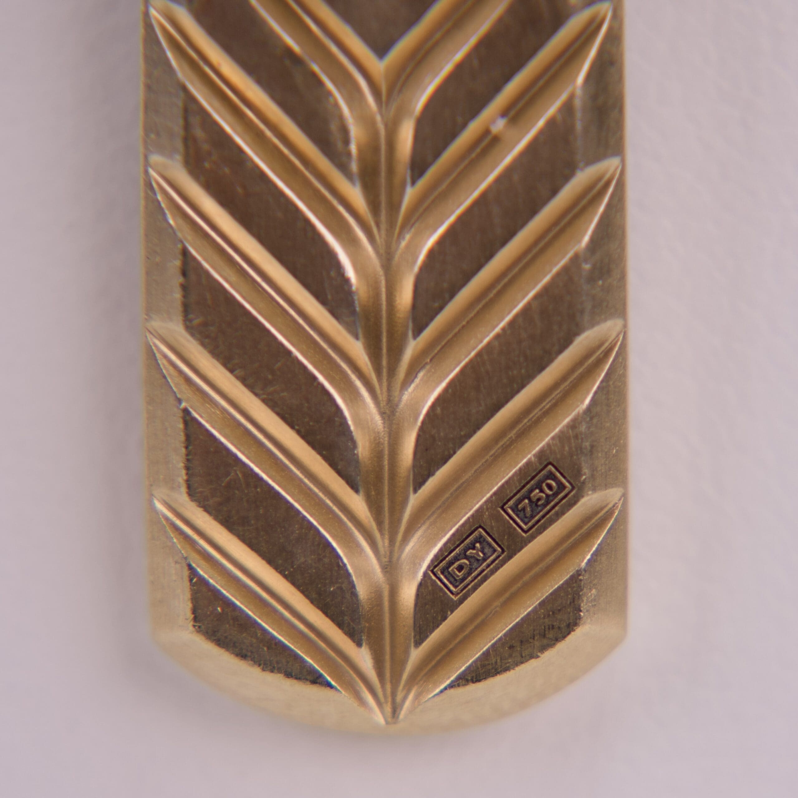Gold palm leaf with engraved symbols.