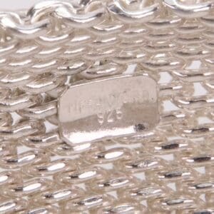 Silver mesh bracelet with engraved label.