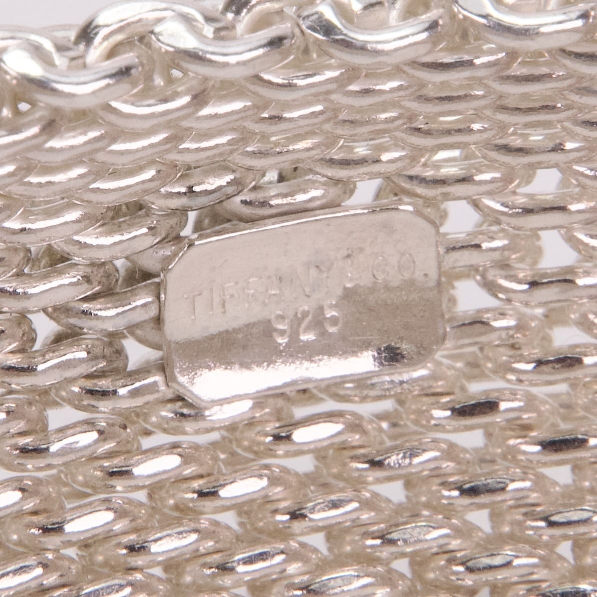 Silver mesh bracelet with engraved label.