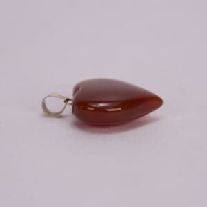 Red heart-shaped pendant on a plain background.