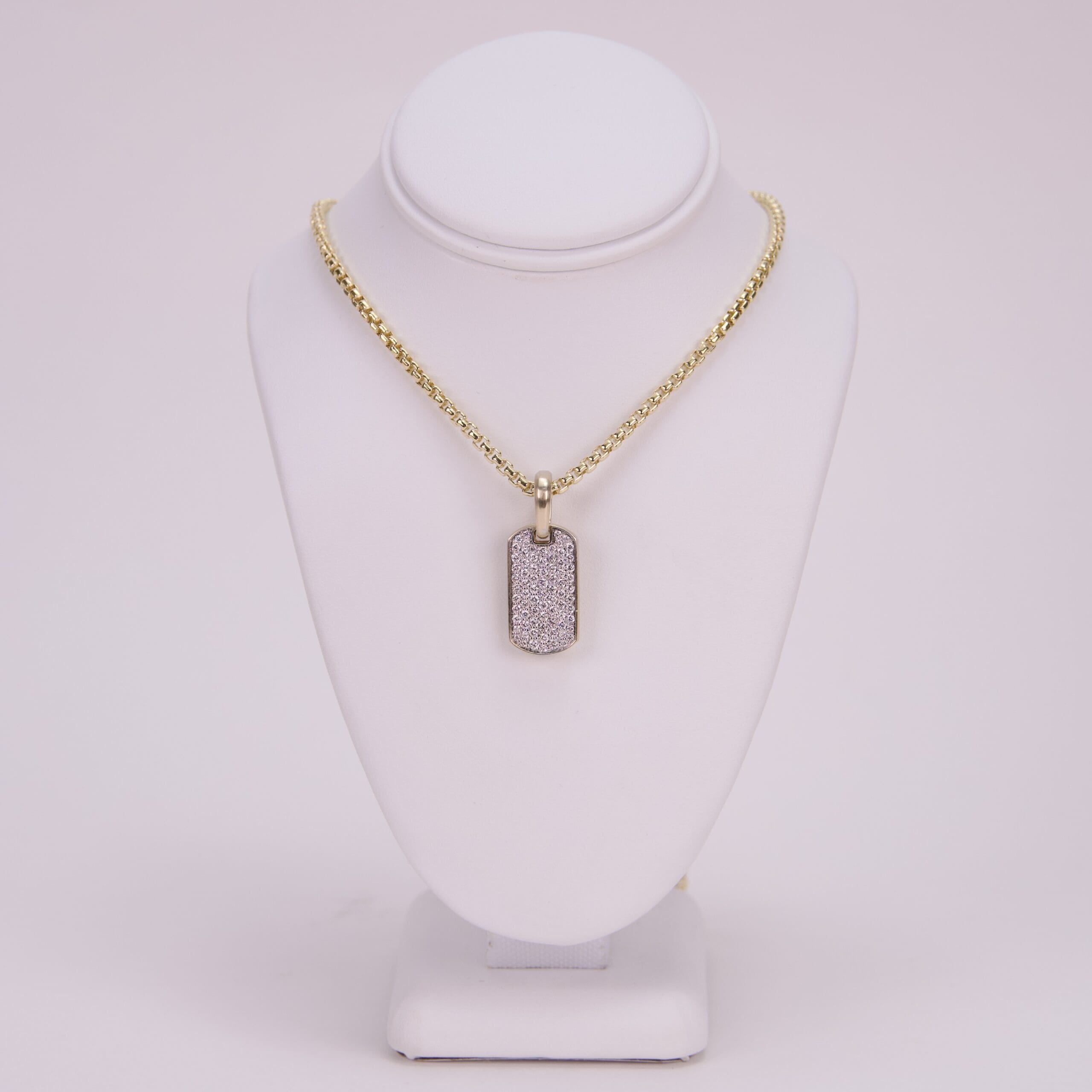 Gold chain with rectangular diamond pendant.