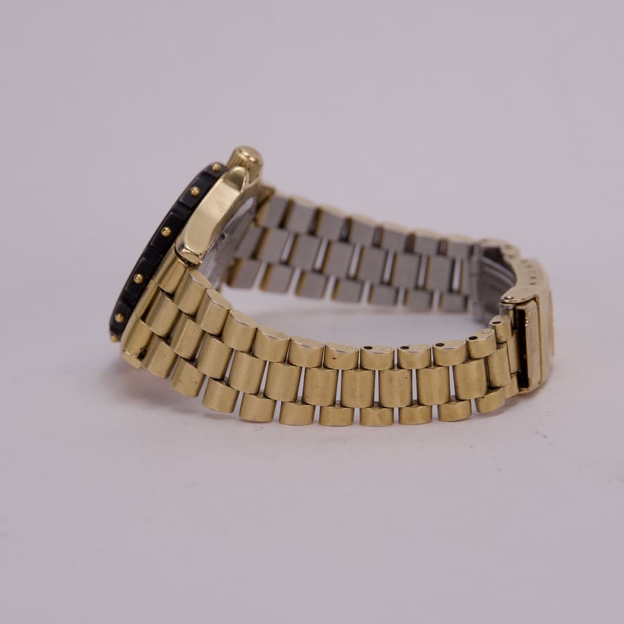 Gold and silver watch with metal band.