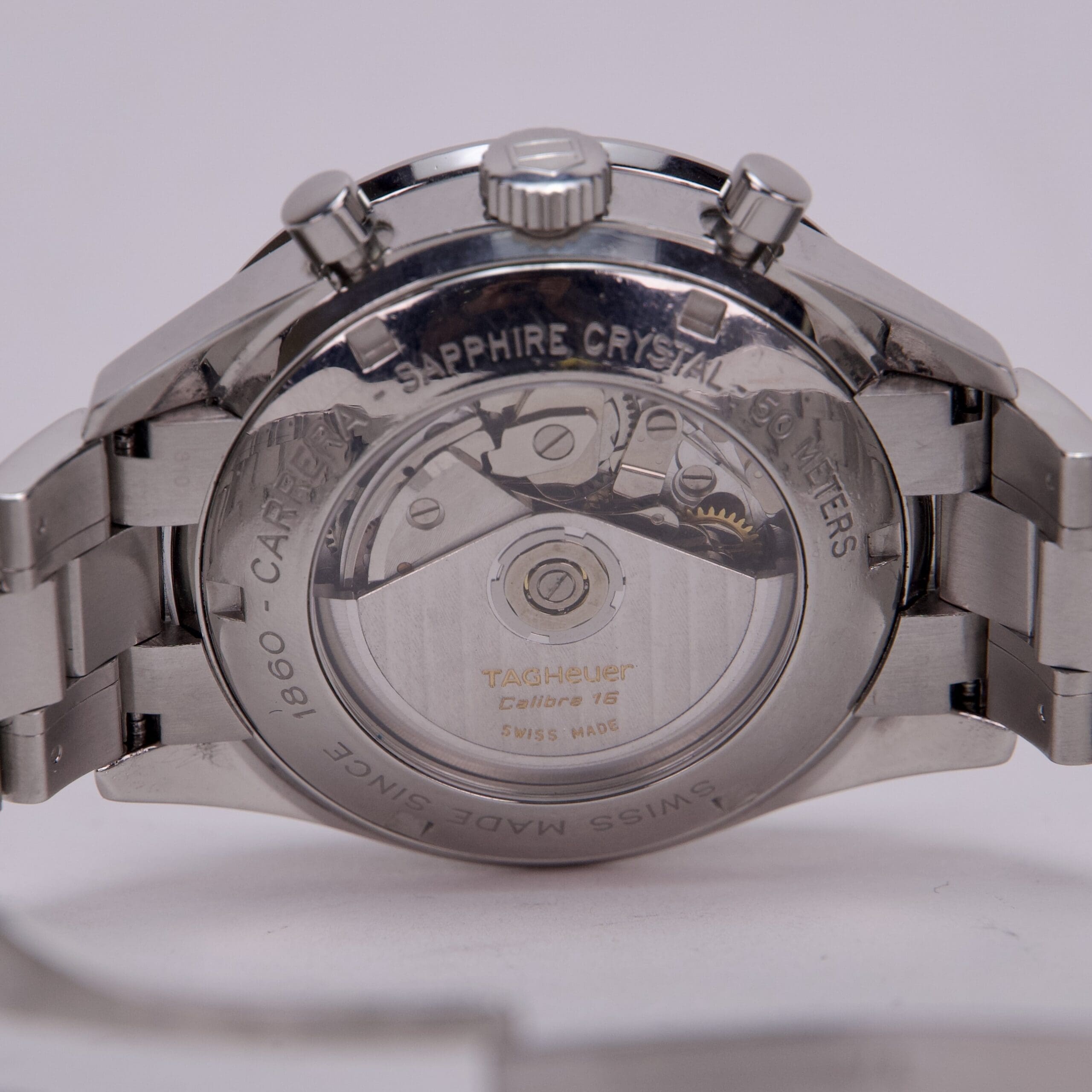 Silver watch with transparent back view.