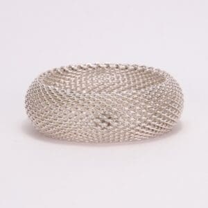 Silver mesh bracelet on white background.