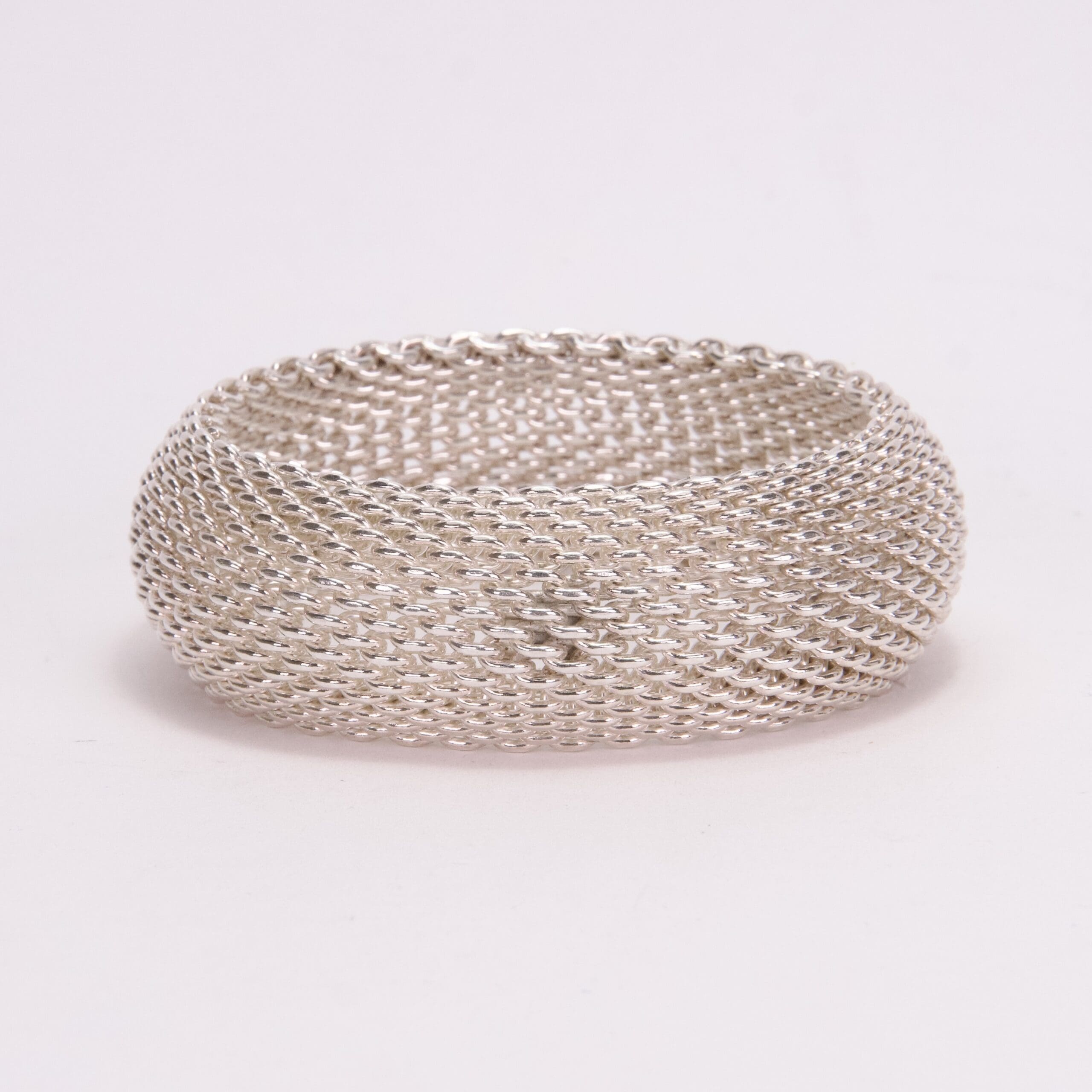 Silver mesh bracelet on white background.