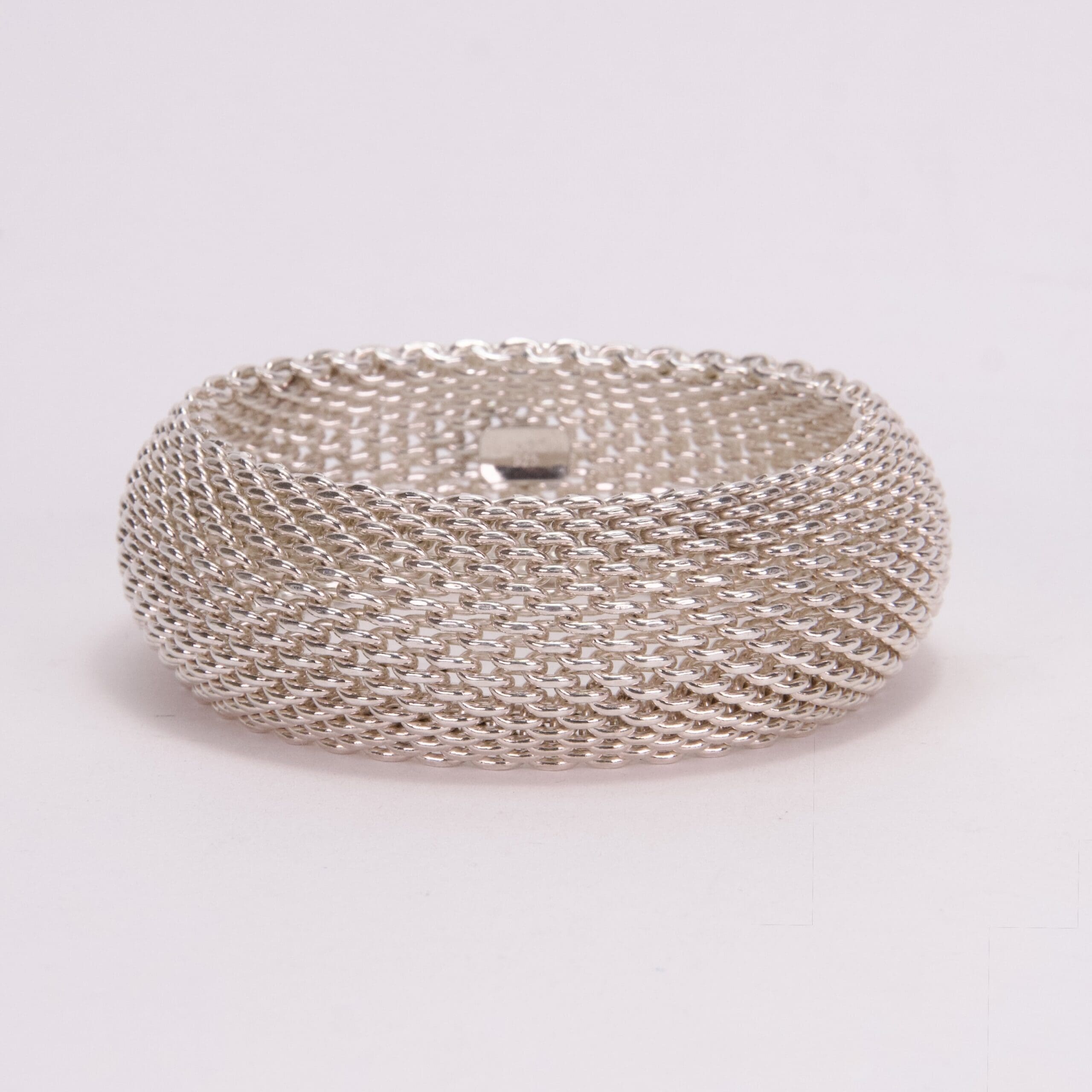 Silver mesh bracelet on white background.
