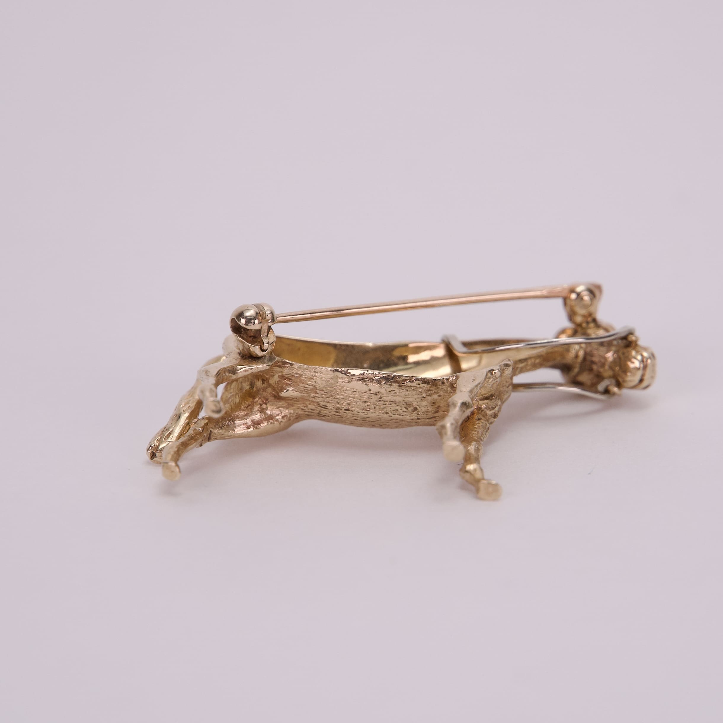 Gold animal-shaped brooch with pin clasp.