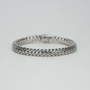 Silver braided bracelet on white background.