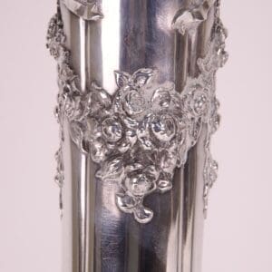Ornate silver vase with floral design.