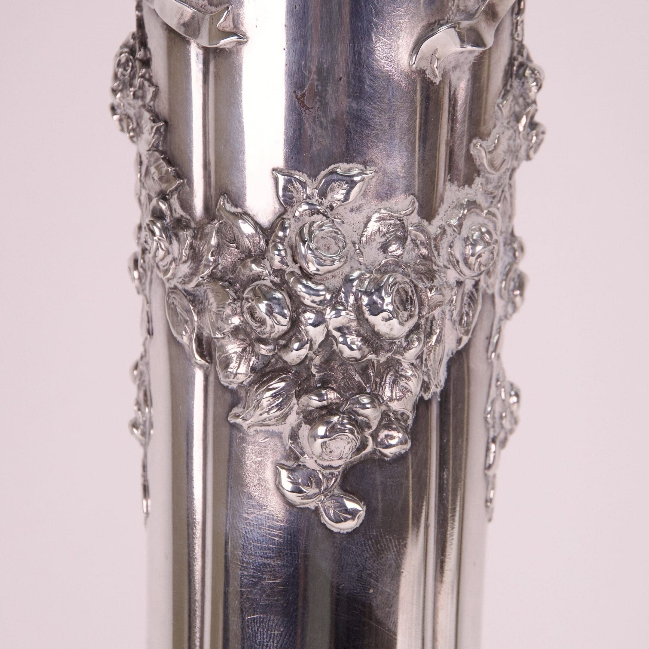 Ornate silver vase with floral design.