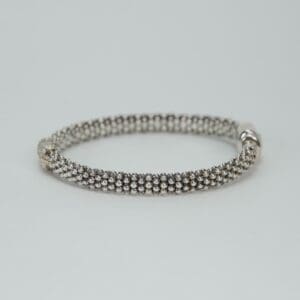 Silver beaded bracelet on plain background.
