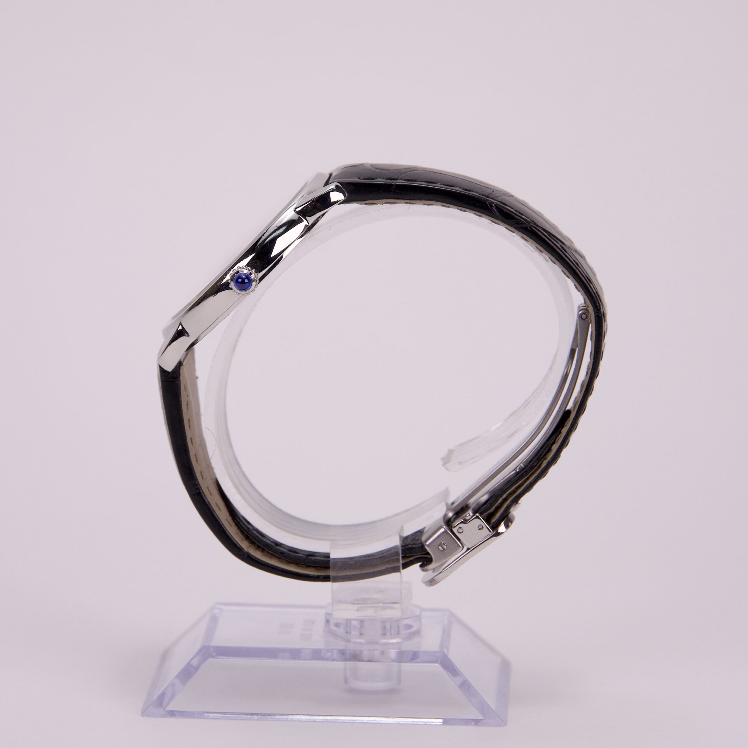 Side view of luxury wristwatch on stand.
