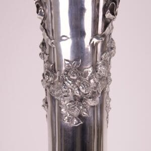 Silver vase with intricate floral design.
