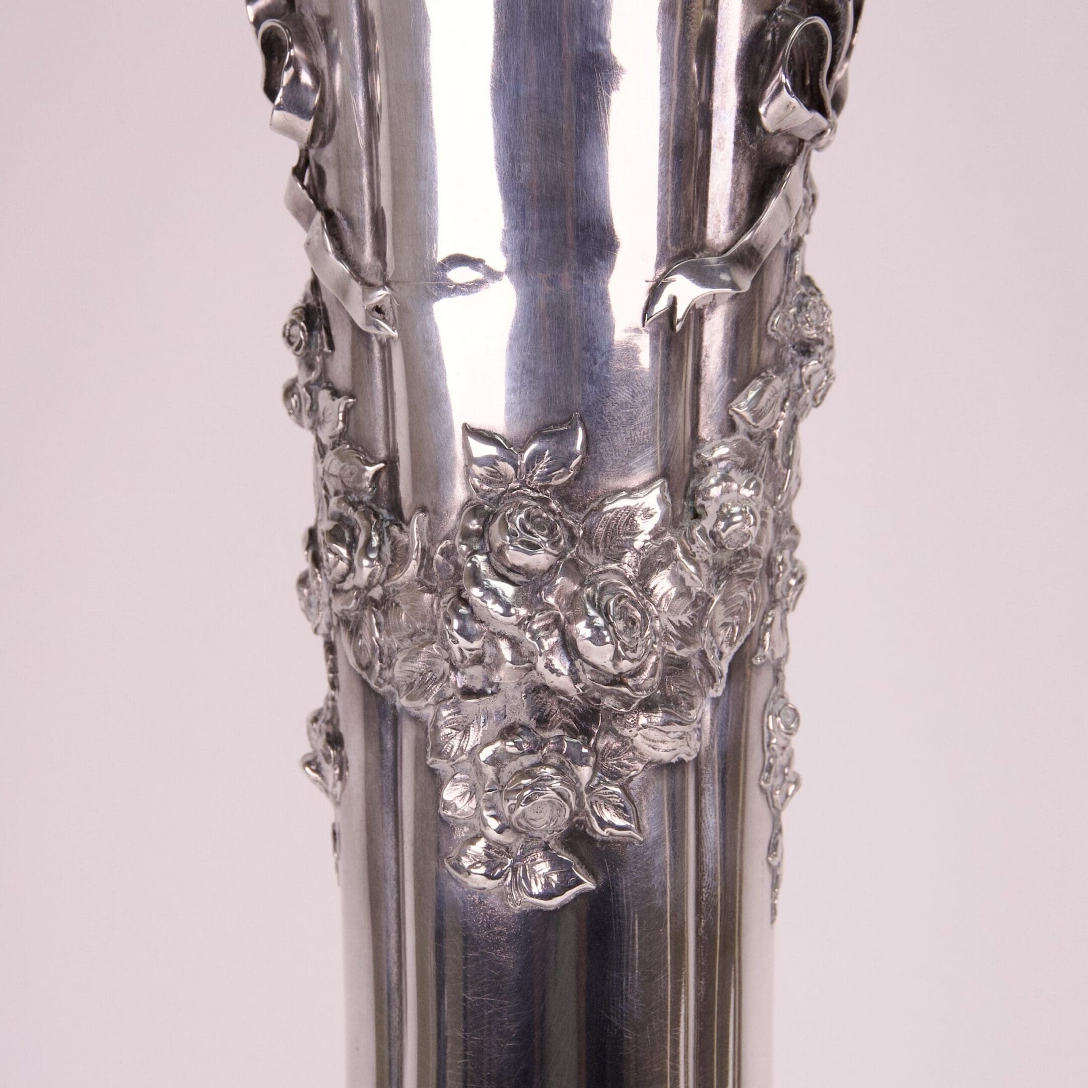 Silver vase with intricate floral design.
