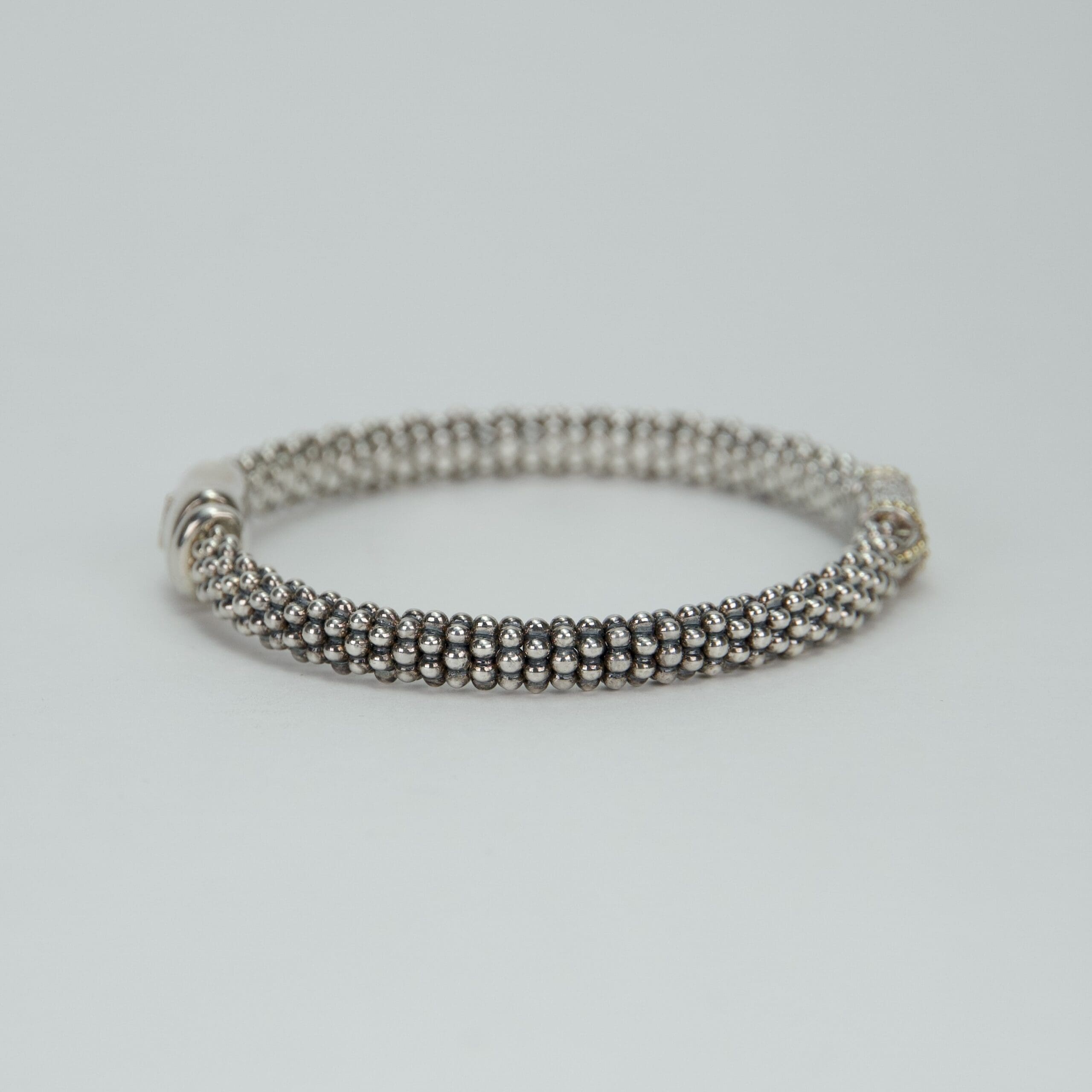 Silver bracelet with beaded design on display.