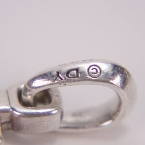 Close-up of silver clasp with engraving.