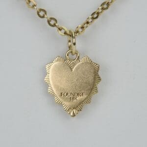 Gold heart-shaped pendant on chain necklace.