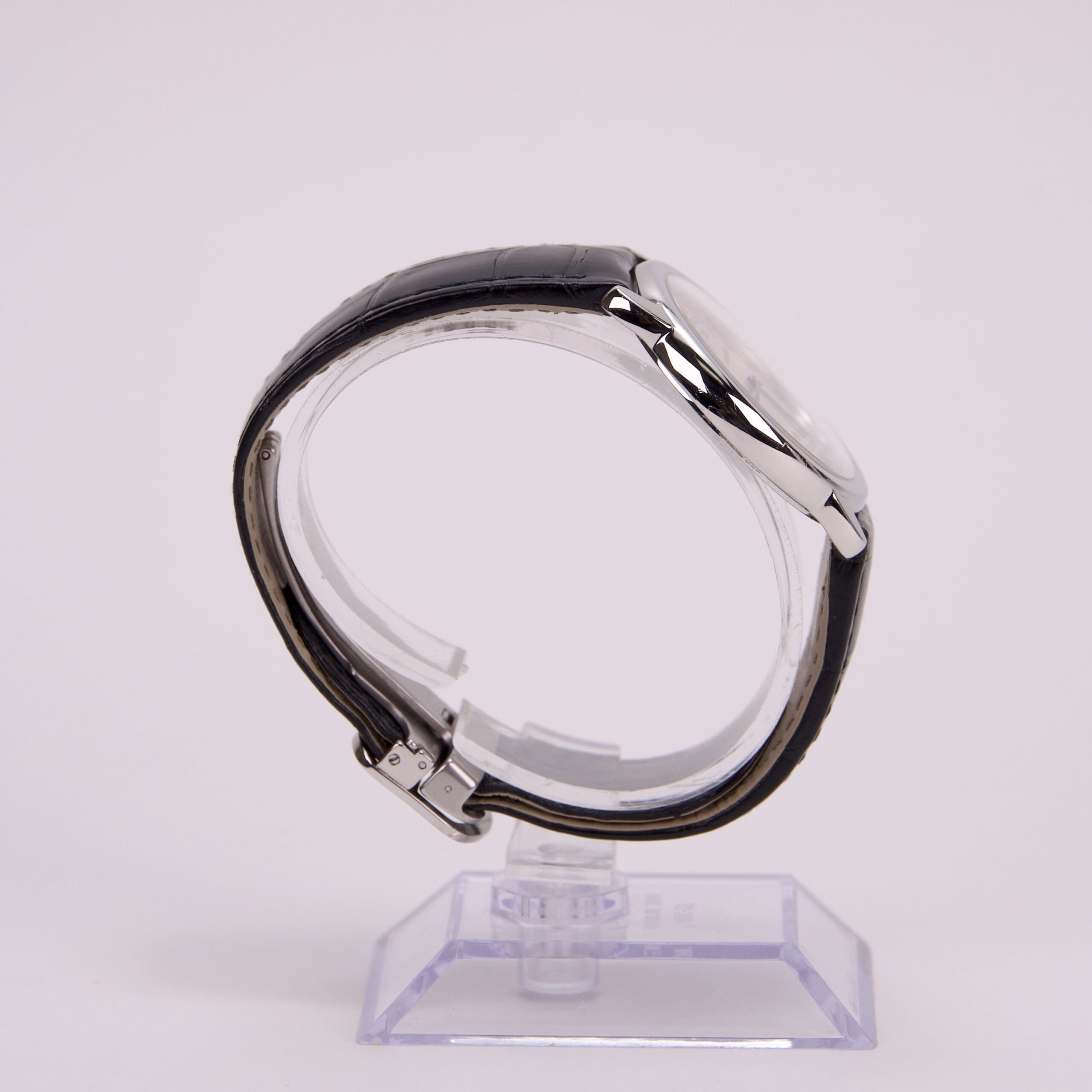 Side view of a wristwatch on stand.