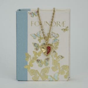 Heart pendant necklace on butterfly-patterned book.