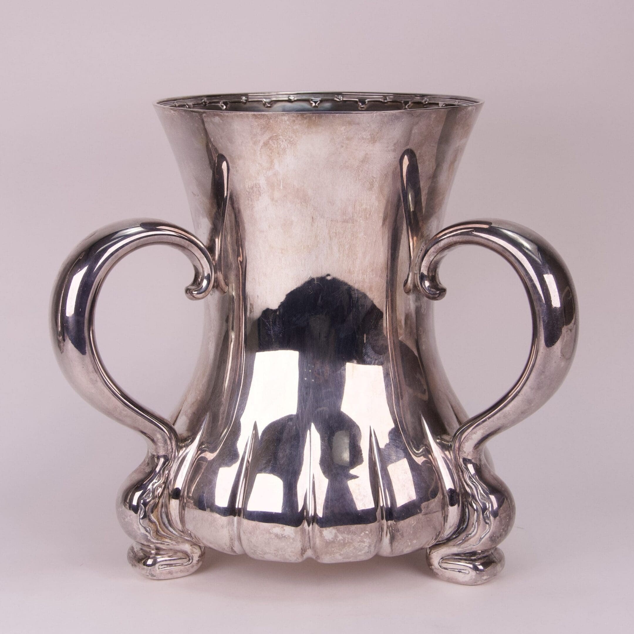 Silver vase with ornate curved handles.