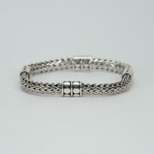 Silver woven bracelet with decorative clasps.