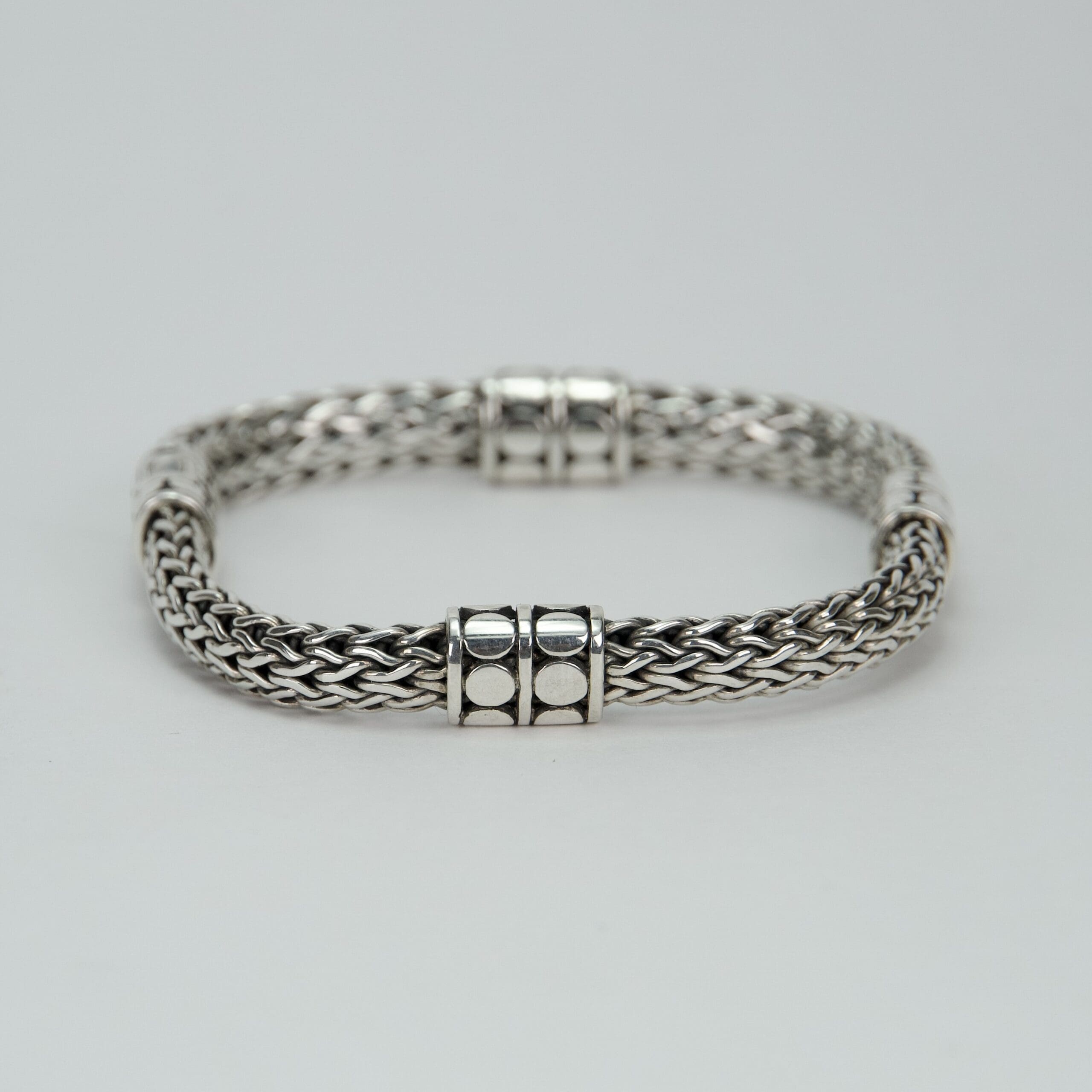 Silver braided bracelet with decorative clasps.