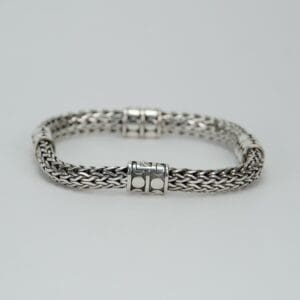 Silver woven bracelet on white background.